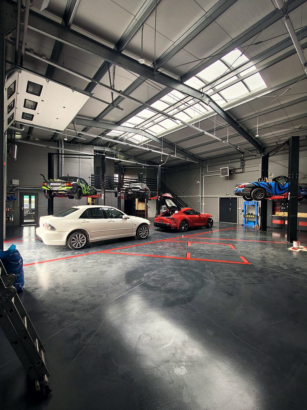 Hala JKN Motors z autami projektowymi na podnośnikach